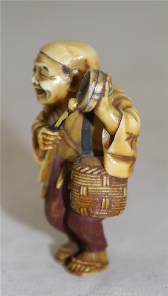 A Japanese tinted ivory figure of a street vendor, Taisho period, 5cm